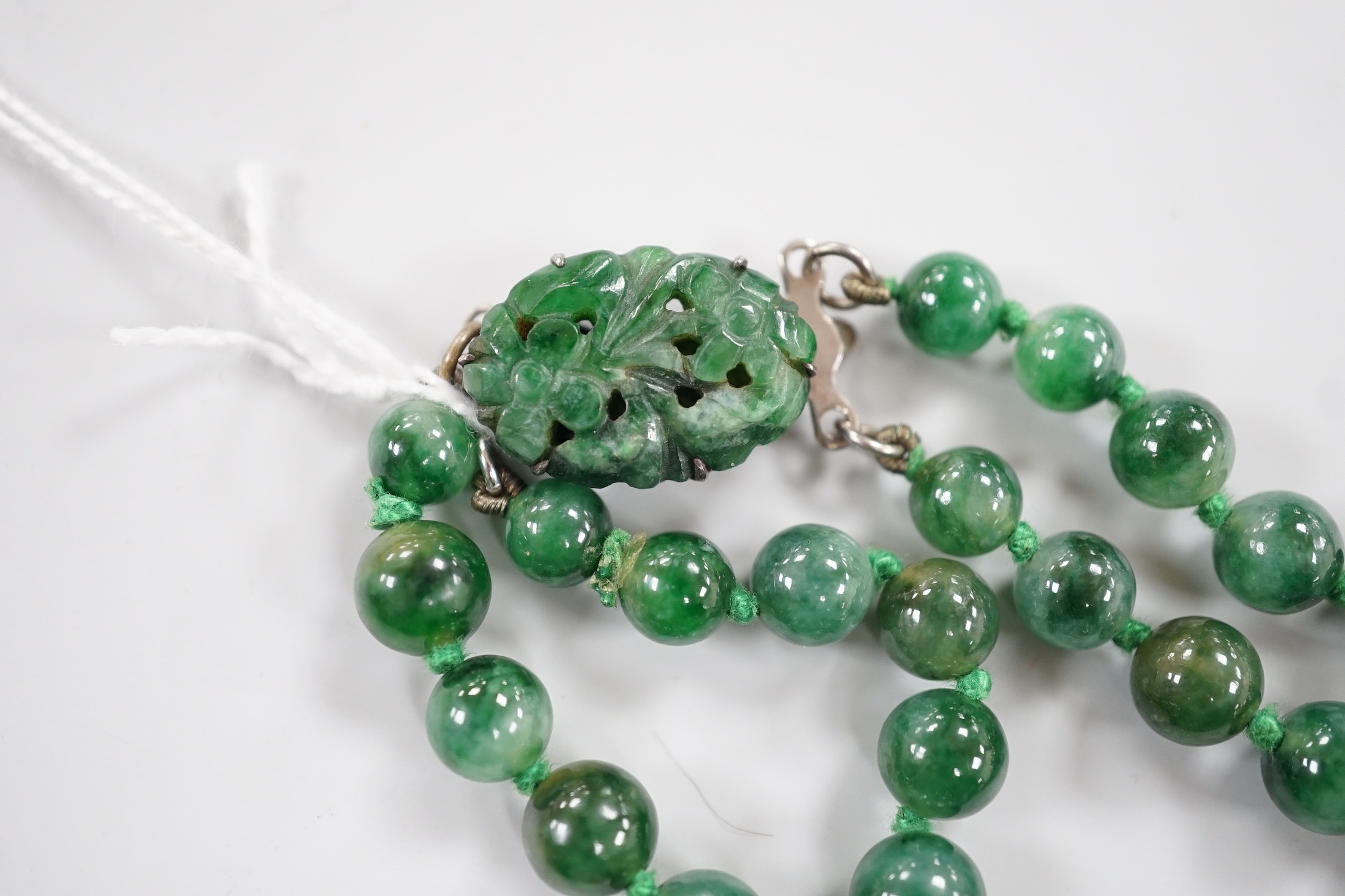 A double strand jade bead necklace, with carved jade and white metal clasp, 45cm, gross weight 101 grams.